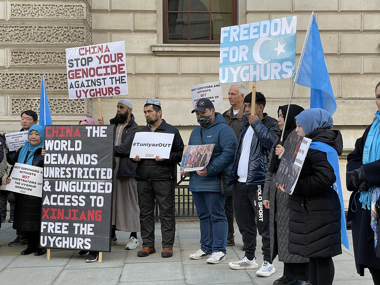 约三十名伦敦人权活动人士及新疆“再教育营”幸存者到英国外交部外示威，抗议新疆维吾尔自治区主席艾尔肯·吐尼亚孜（Erkin Tuniyaz）访问英国，并可能获安排和英国外交部官员会晤。 （吕熙摄）
