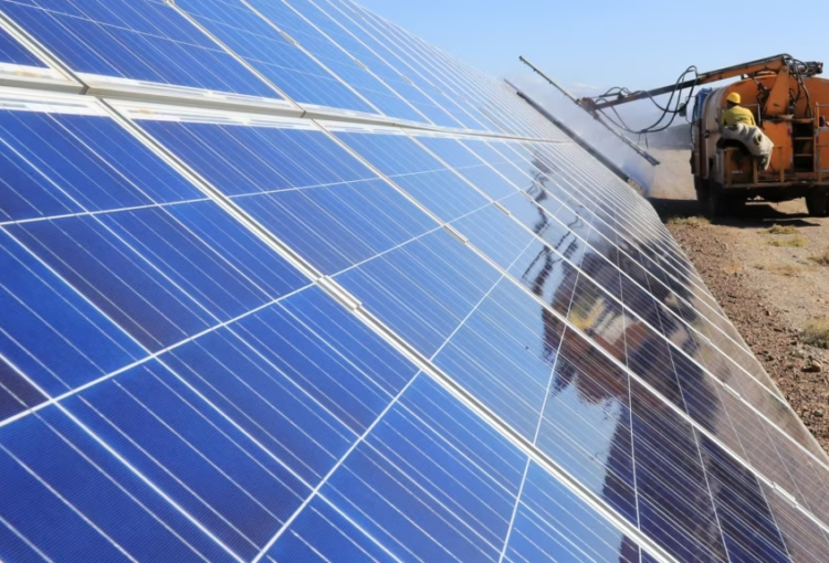 2018年10月22日工人在中国新疆维吾尔自治区哈密的光伏产业园操作机器清洁太阳能电池板